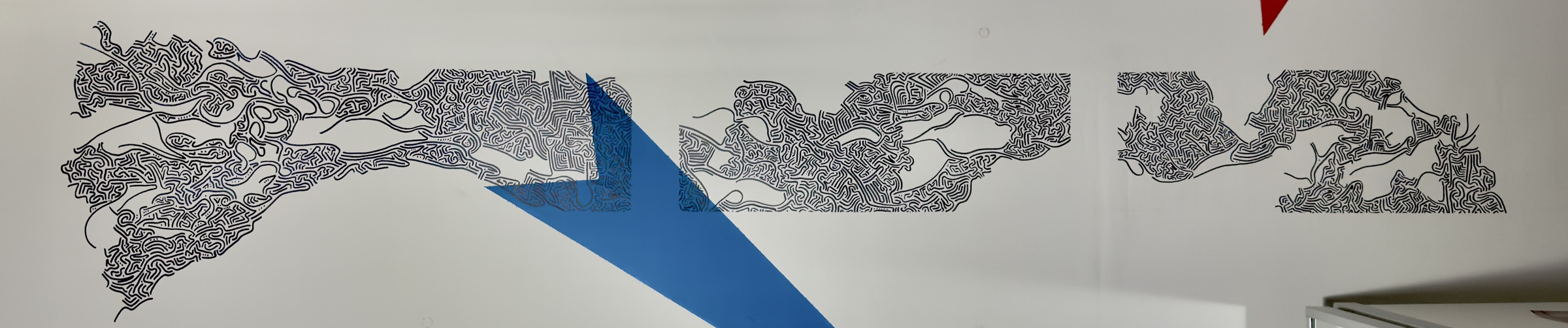 Murale su soffitto d'interno con linee nere e una freccia geometrica blu